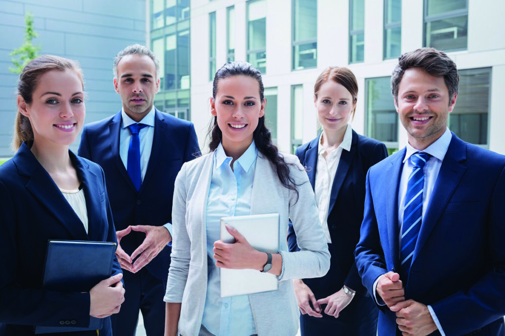 Portrait of confident businesspeople standing outside office building Immobilienverwalter:in